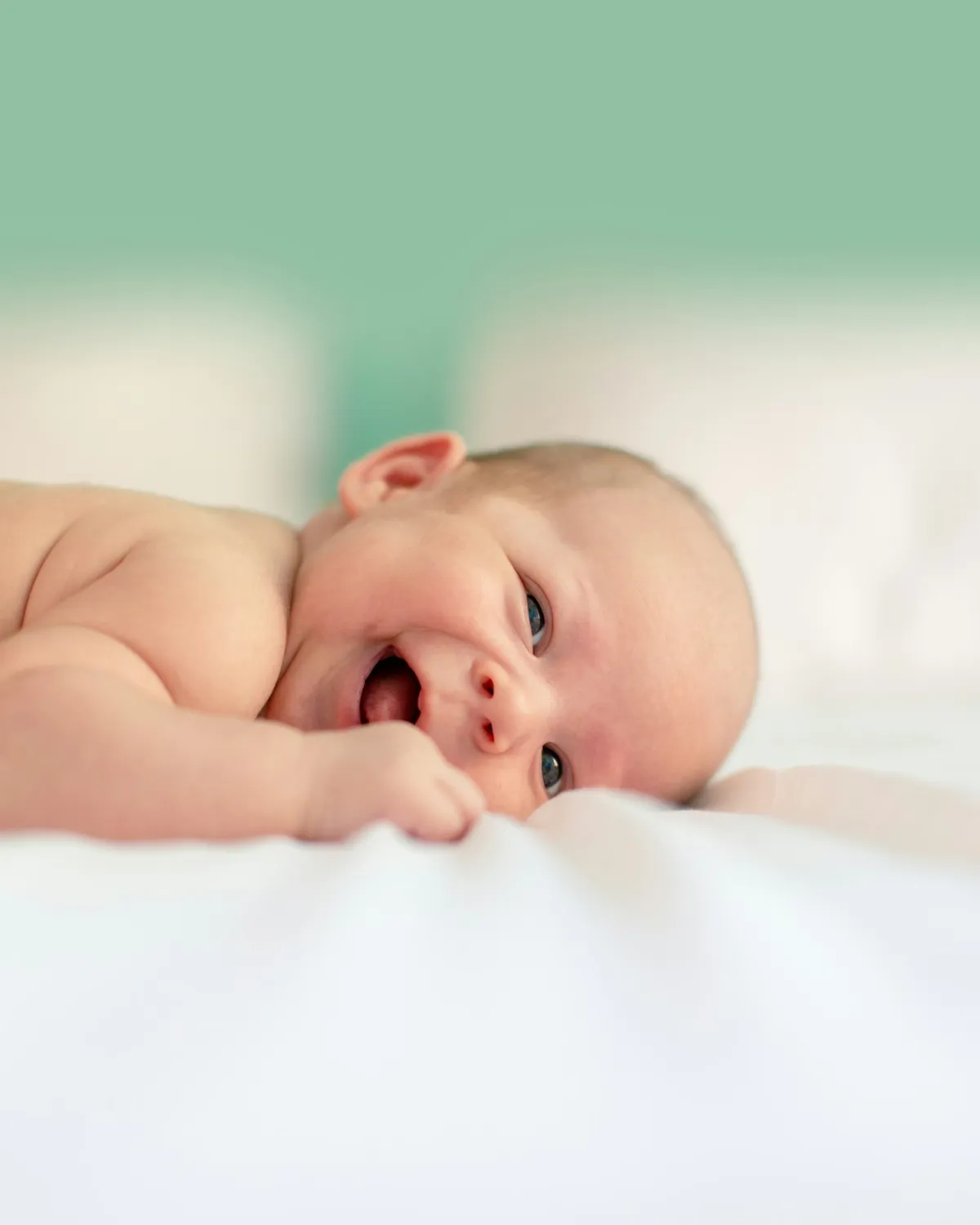 Foto de un bebé sonriendo en la cama