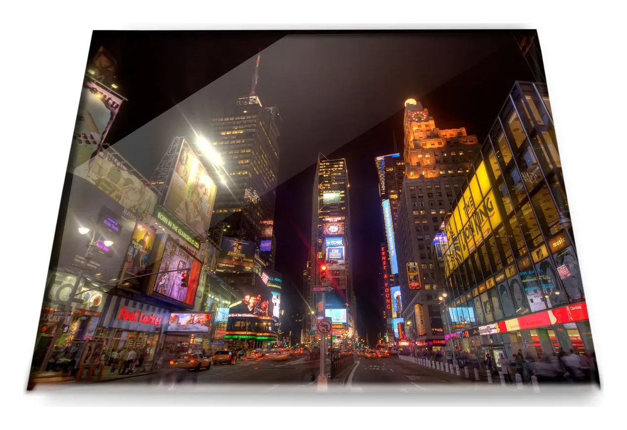 Un cuadro de cristal con una fotografía nocturna de ciudad, visto en ángulo