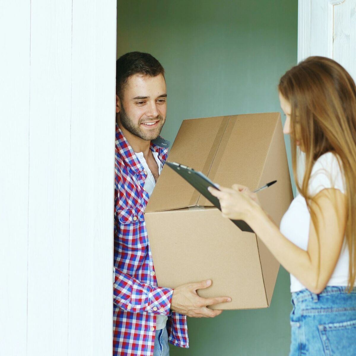 Una pareja recibe su paquete en la puerta de su casa