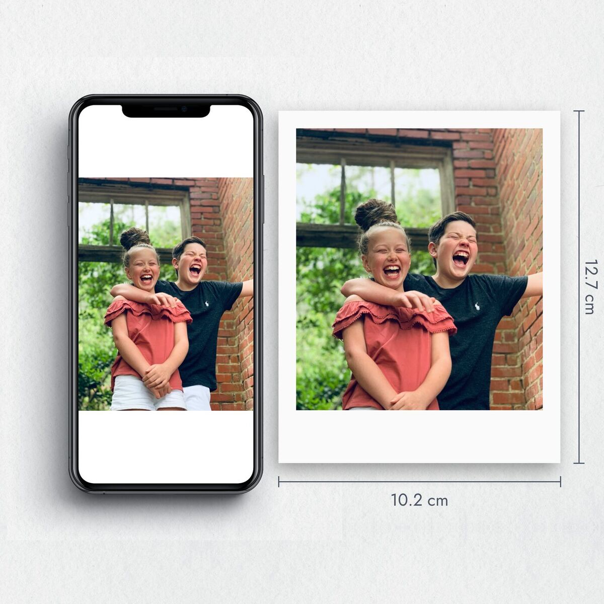 Foto tipo polaroid de 10.2 × 12.7 cm junto a un celular
